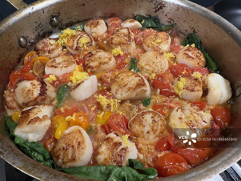 炉子上平底锅中的炒扇贝图片素材