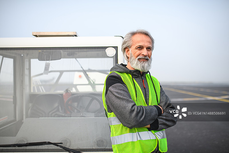 机场跑道上的白人后推拖车司机图片素材