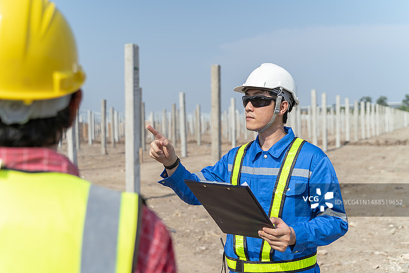 建筑工地与同事讨论的亚洲工程师图片素材