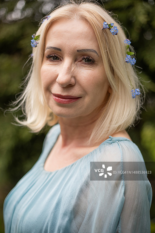 戴着勿忘我花的金发年长女性肖像图片素材