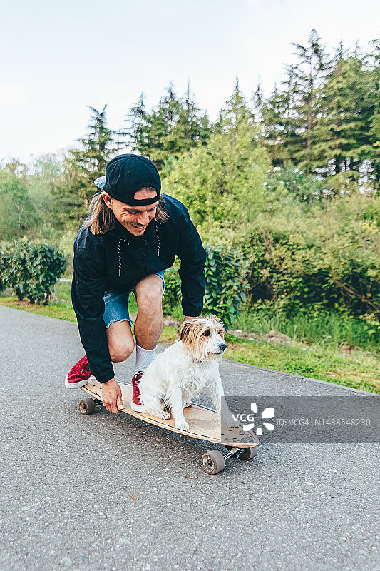 杰克罗素梗犬与主人一起玩滑板图片素材