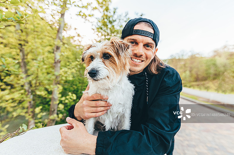 快乐的中年男人和杰克罗素梗犬一起散步图片素材