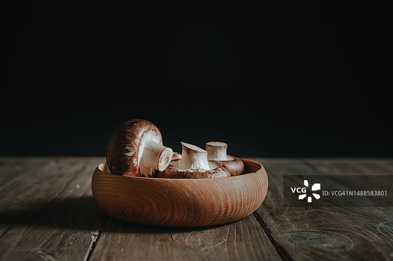 木碗里黑背景上的棕色蘑菇图片素材