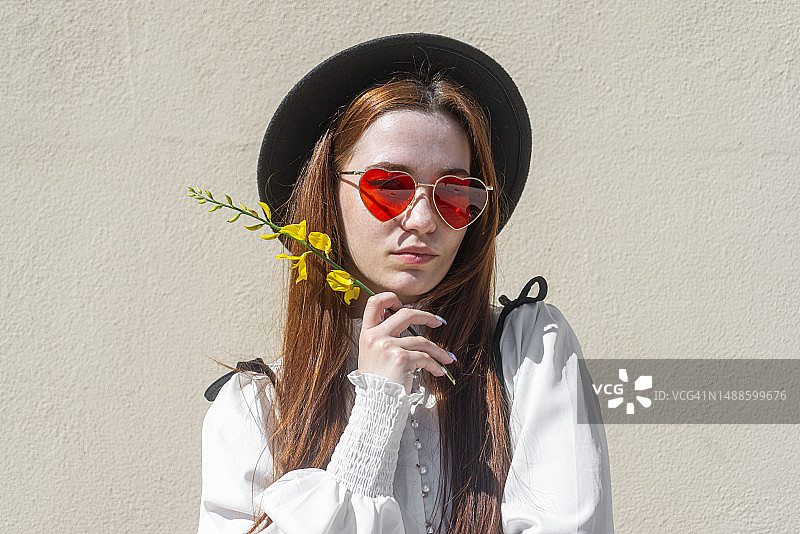 戴着帽子、太阳镜和羽扇豆花的女人图片素材