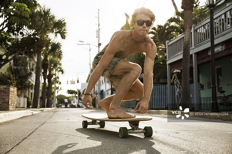 在基韦斯群岛的道路上滑冰的赤膊年轻人图片素材