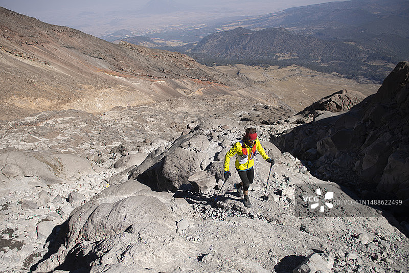 一名男子在奥里萨巴峰的崎岖地形中拄着登山杖徒步旅行图片素材