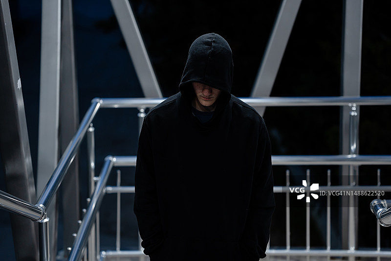 独自站在人行天桥上的沮丧年轻男子图片素材