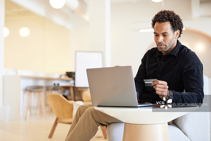 商人使用笔记本电脑和信用卡进行网上购物图片素材