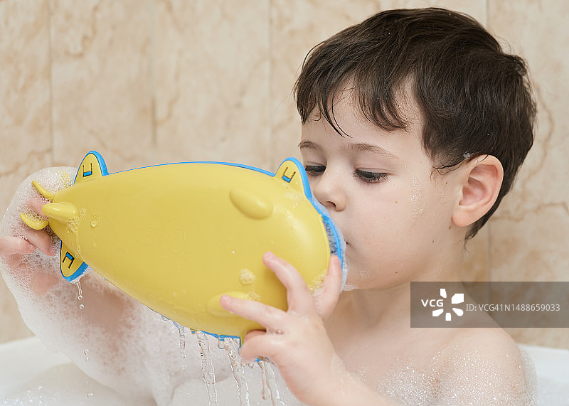 在浴缸里玩耍的可爱小男孩图片素材