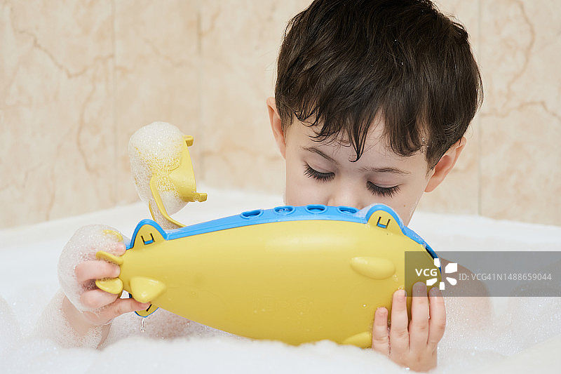 在浴缸里玩耍的可爱小男孩图片素材