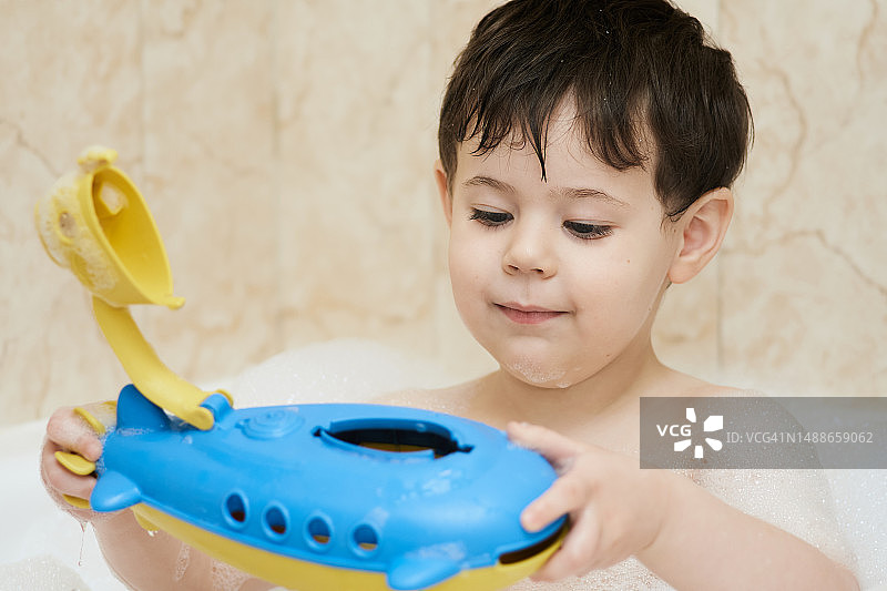 在浴缸里玩耍的可爱小男孩图片素材