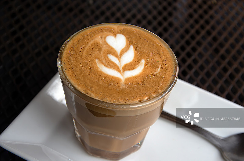 金属网户外咖啡桌上的玻璃杯平白牛奶咖啡图片素材