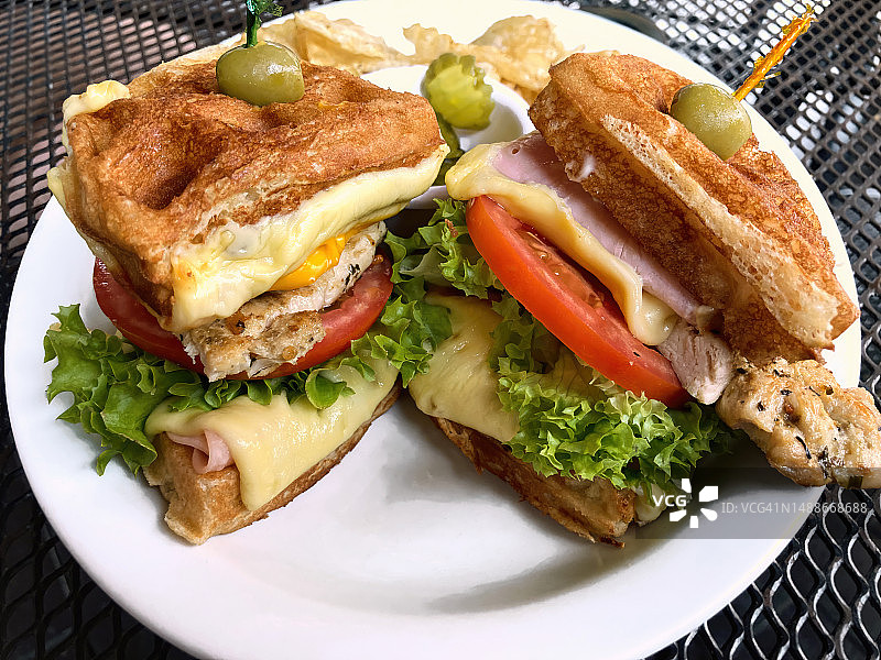 夹有火腿、奶酪和鸡胸肉的华夫饼三明治图片素材