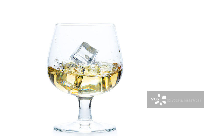 白色背景下，球形杯中加冰的威士忌或白兰地图片素材