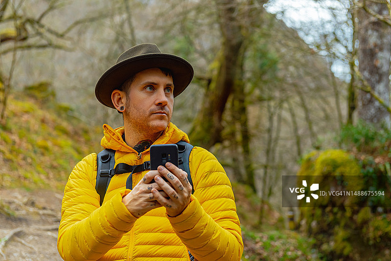 用智能手机在森林中导航的徒步者图片素材