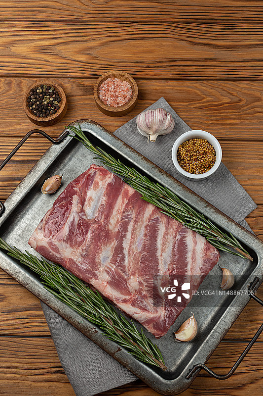 托盘里的生猪排，配香草、香料和大蒜图片素材