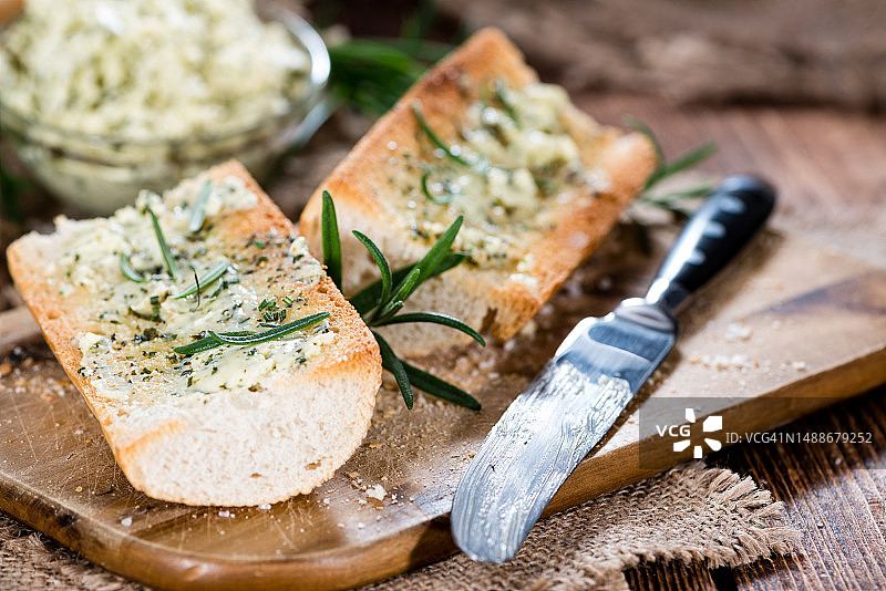 乡村木质背景上的香草黄油蒜香法棍图片素材