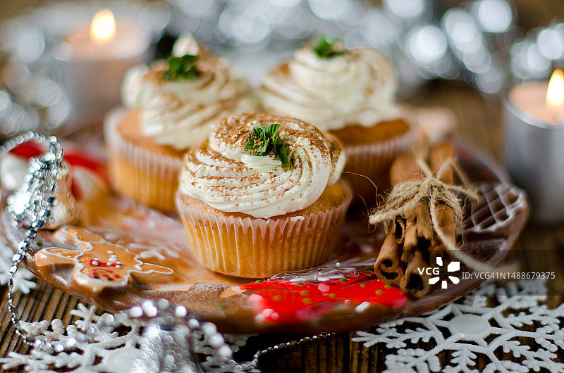 圣诞装饰餐桌上的奶油圣诞纸杯蛋糕，罗马尼亚图片素材