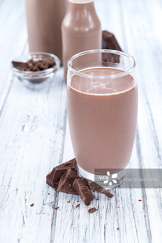 明亮木纹背景上的新鲜自制巧克力牛奶图片素材