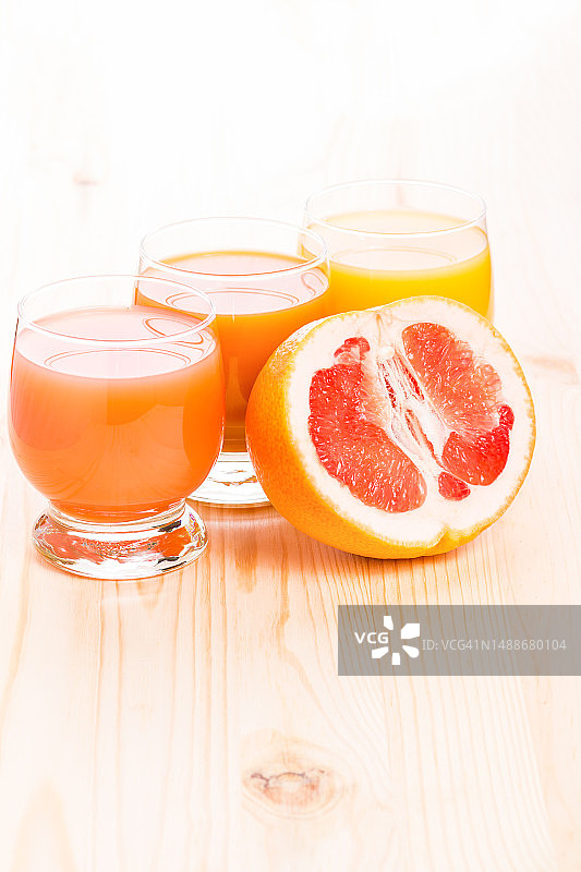 三杯果汁与半个葡萄柚，置于木桌之上，健康食品背景，罗马尼亚图片素材