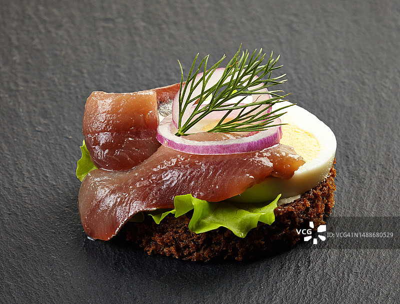 黑背景上的凤尾鱼和鸡蛋小吃图片素材