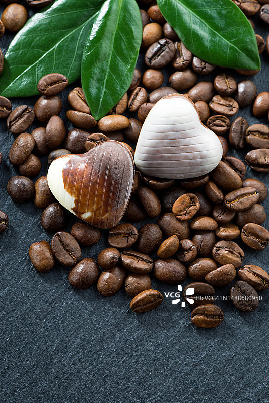 深色背景上心形咖啡豆和巧克力糖果（竖版，顶视图）图片素材