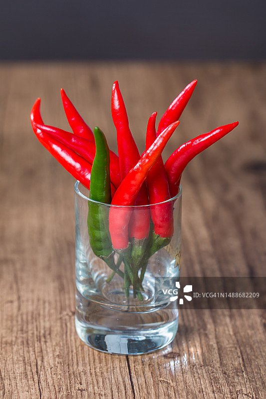 木质背景上的玻璃罐装红辣椒图片素材