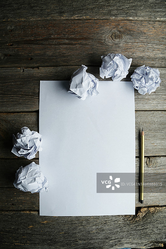 灰色木质背景上的褶皱纸张、白纸和铅笔图片素材
