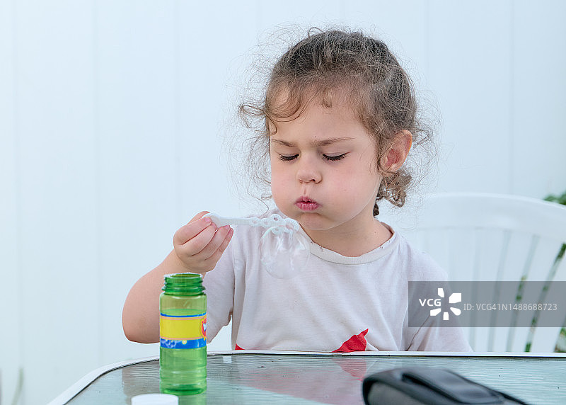 可爱的年轻女婴在后院玩肥皂泡图片素材