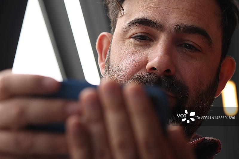 在咖啡馆使用智能手机的男人图片素材