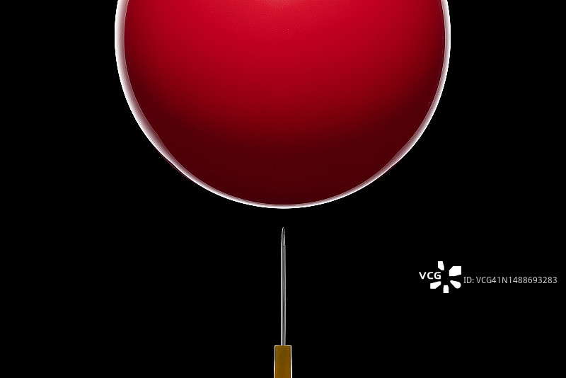 危机概念：即将刺破红色气球的尖锐针头图片素材