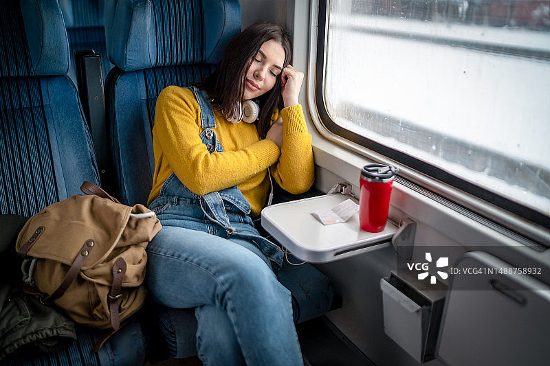 年轻女子在火车上小憩图片素材
