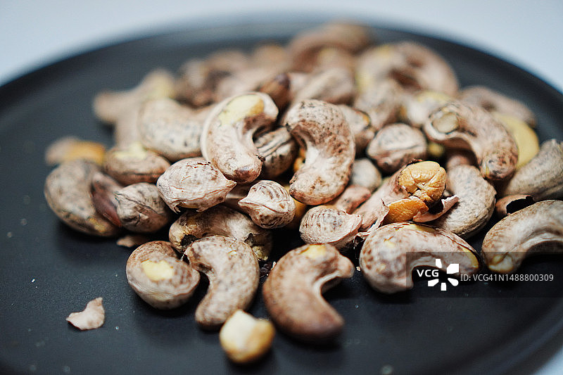 黑盘中的腰果图片素材