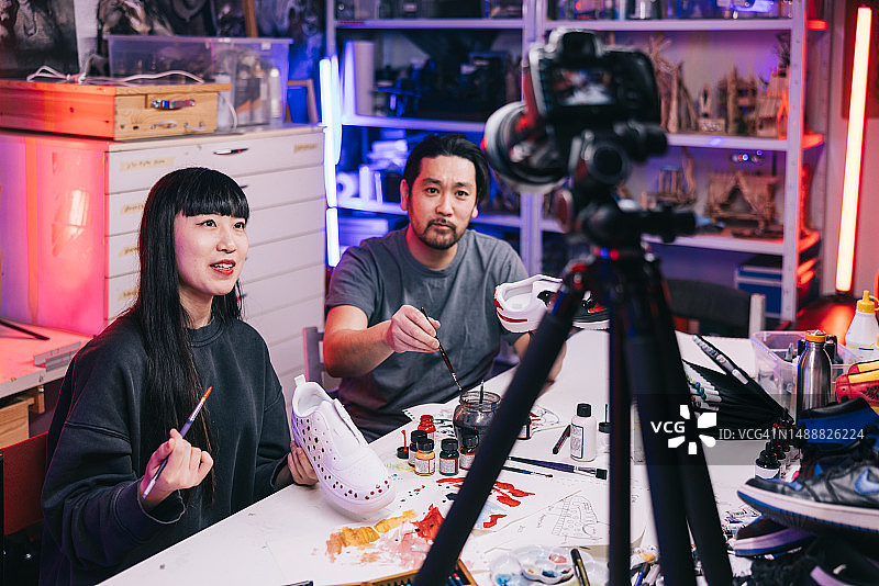 两位运动鞋艺术家在工作室制作教学视频图片素材