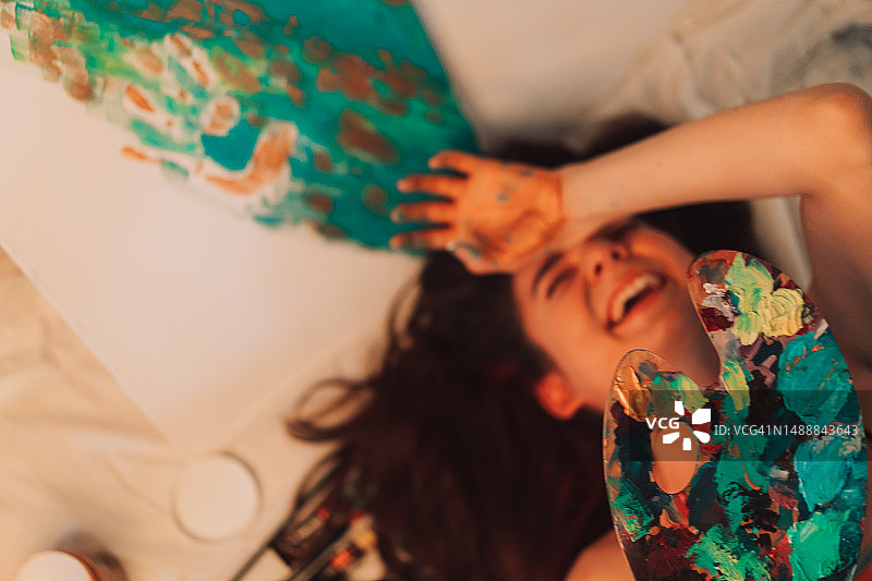 欢笑的女孩躺在地板上，有图案和调色板图片素材