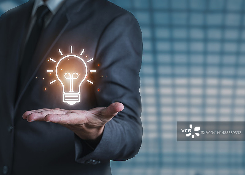 商人手持创意灯泡，展示想法图片素材