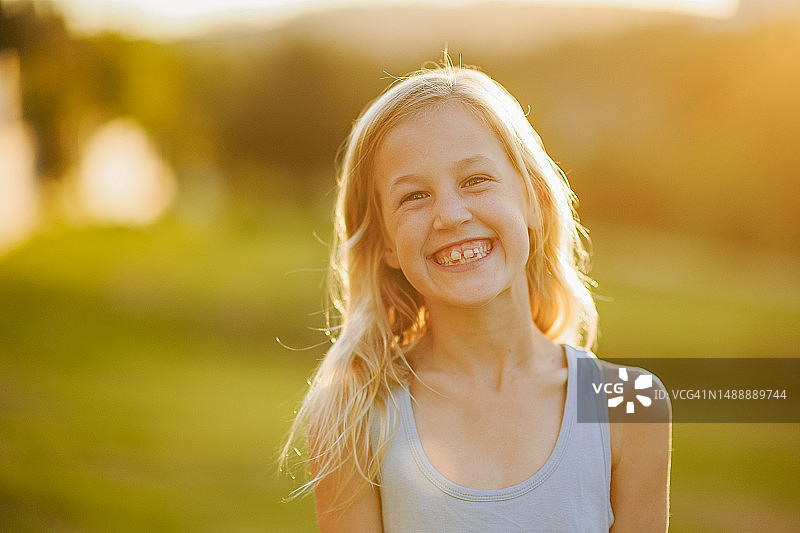 日落时分，金发年轻女子回眸一笑图片素材