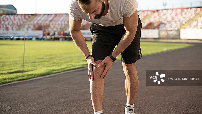 青年男子慢跑时膝盖受伤图片素材