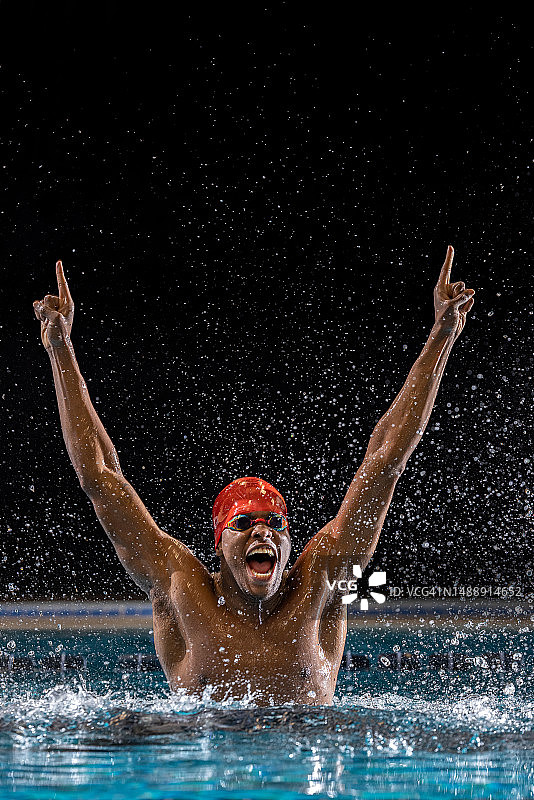黑人男游泳运动员赢得比赛后举起双臂庆祝图片素材