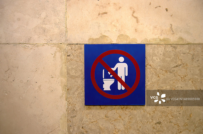 厕所隔间墙上的标志，指示卫生纸不应冲入马桶，因为它会堵塞下水道图片素材