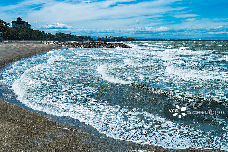 白色海浪拍打的沙滩，位于日本三重县伊势市图片素材