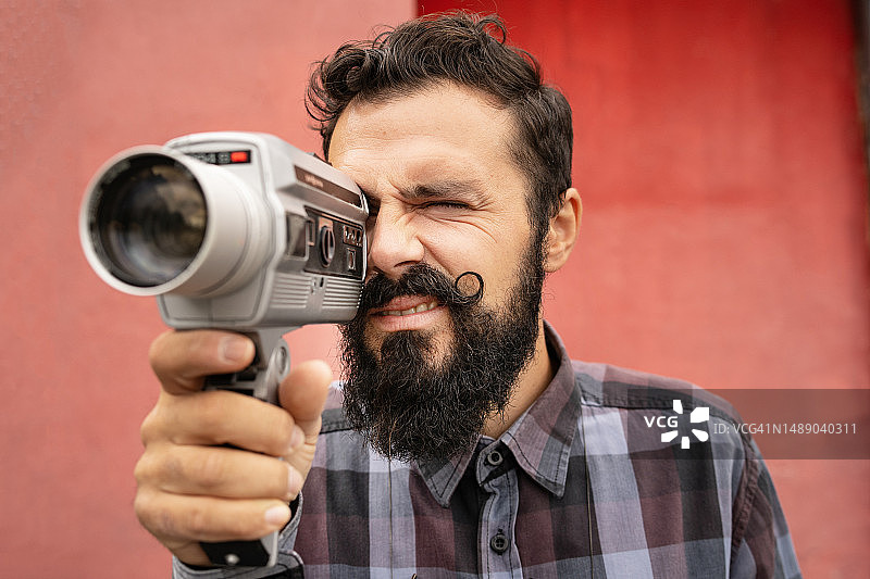 年轻男人用复古相机拍摄视频图片素材