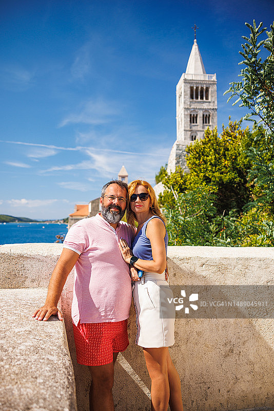 快乐的已婚夫妇在夏季假期参观海边古镇图片素材