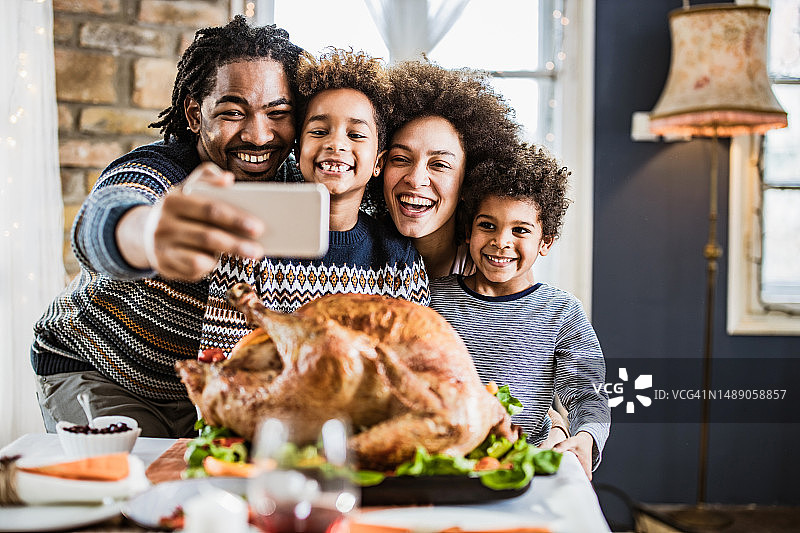 在感恩节午餐期间自拍的快乐非裔美国家庭图片素材