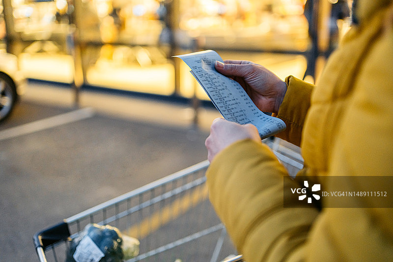 查看超市购物小票的年轻女人图片素材