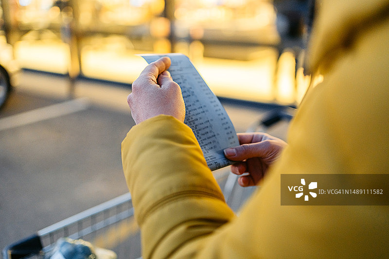 查看超市购物小票的年轻女人图片素材