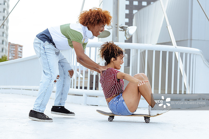 情侣在城市里玩滑板图片素材