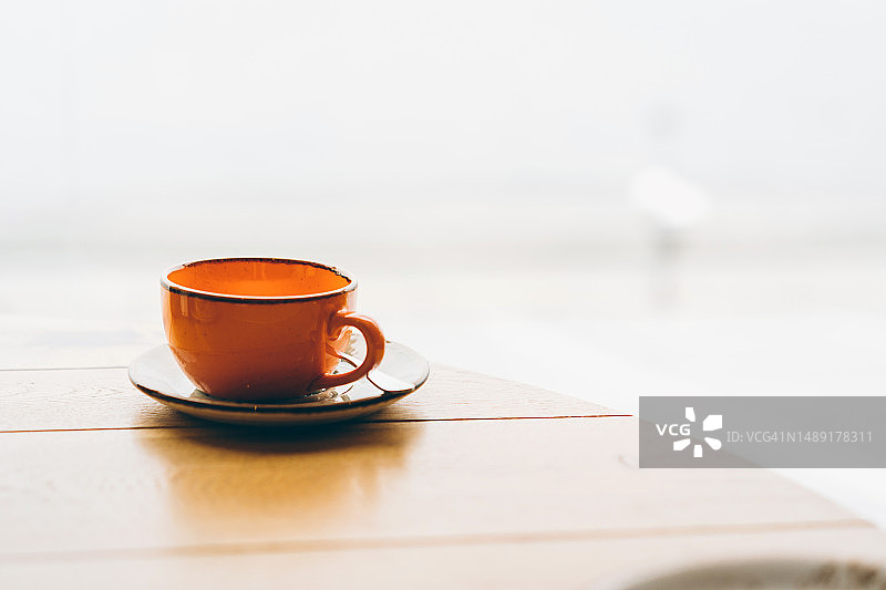 木桌上的橙色茶杯图片素材