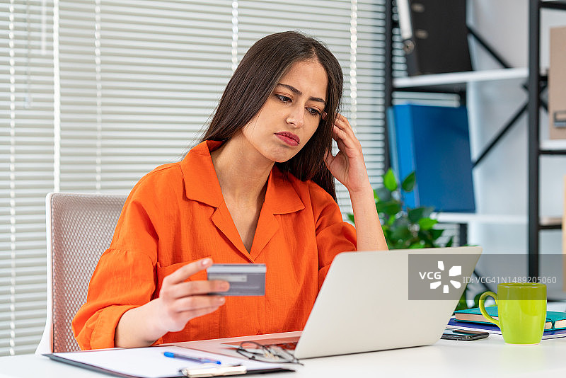 金融问题，网上购物不成功。震惊的女人拿着笔记本电脑和信用卡图片素材