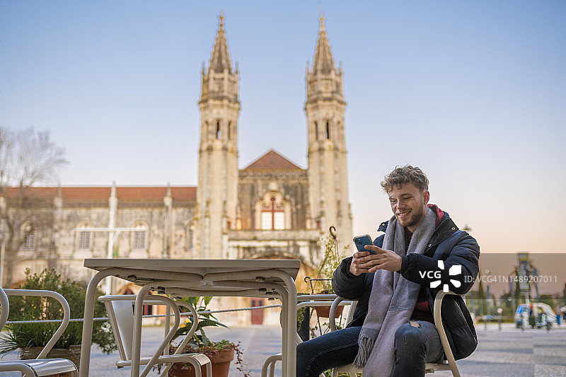 在户外酒吧使用智能手机的男人图片素材